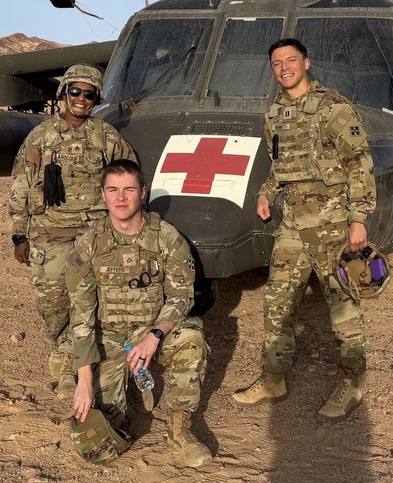 Dr. Bennett with two soldiers beside a medevac helicopter